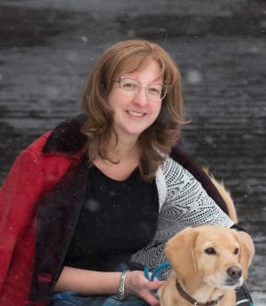 A woman and her dog are posing for the camera.