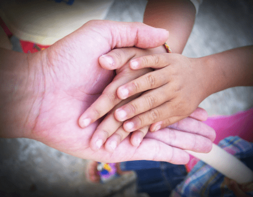 A close up of two hands with one hand holding another